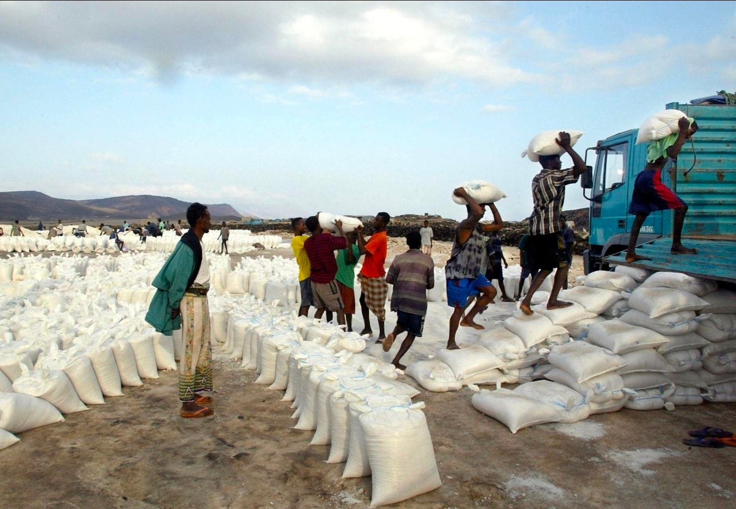 Workers loading sacks of Lac Assal salt onto a truck for export